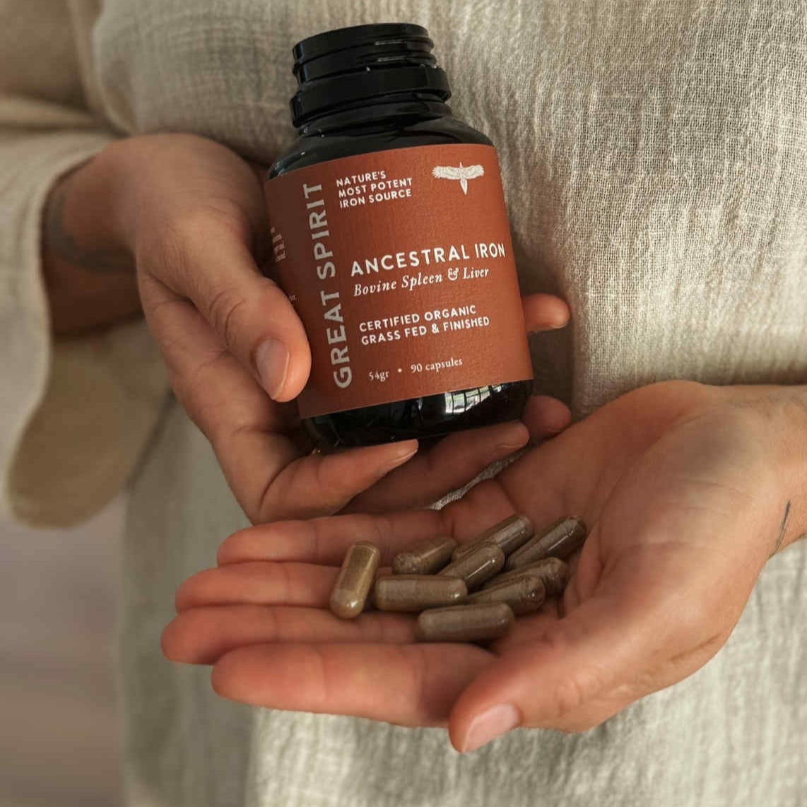 Person holding a bottle of 'Great Spirit' vitamins and pills.